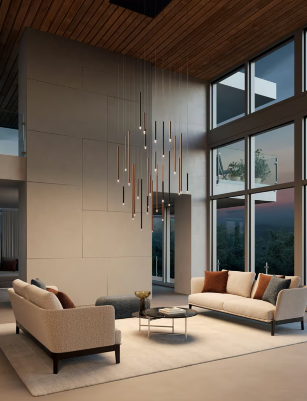 Salon moderne avec deux canapés beiges, suspension design composée de multiples tiges lumineuses et grandes baies vitrées laissant entrer la lumière du soir.
