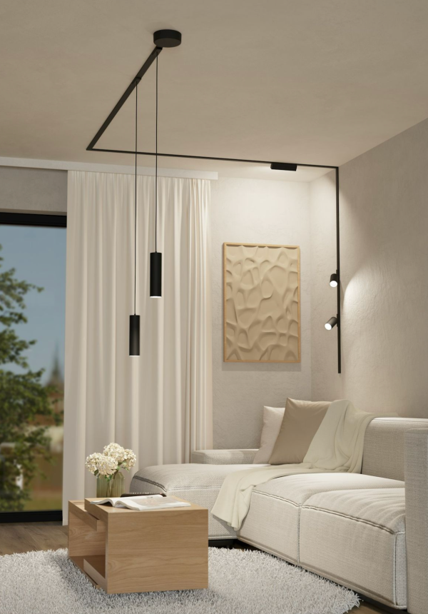 Salon moderne avec canapé clair, éclairé par deux suspensions noires cylindriques et un ensemble de spots muraux orientables.