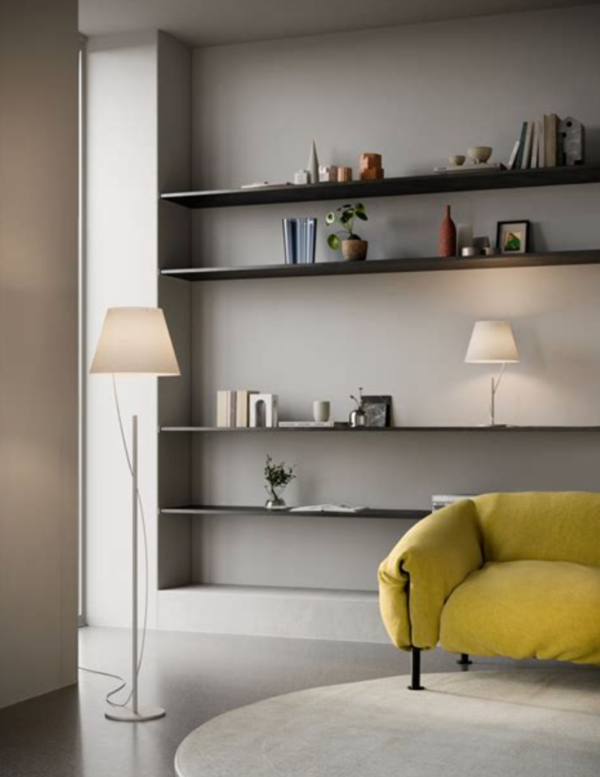 Salon contemporain avec fauteuil jaune, éclairé par un lampadaire et une lampe de table assortis diffusant une lumière douce.