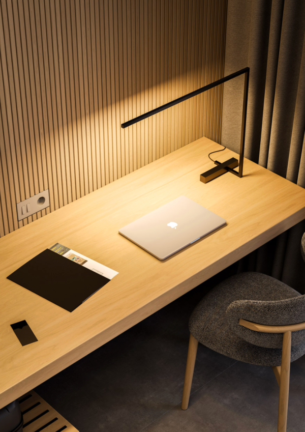Light wood desk with focused lighting, closed laptop, and warm atmosphere.