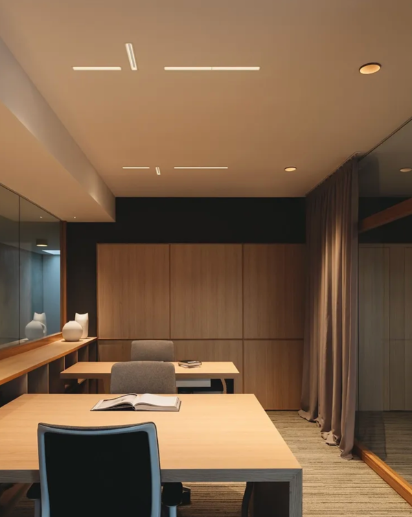 Warm workspace with recessed lighting, light wood furniture, and a cozy atmosphere.