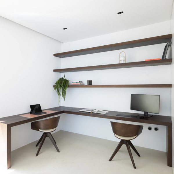 Bright minimalist office with an L-shaped desk, wooden shelves, and contemporary furniture.