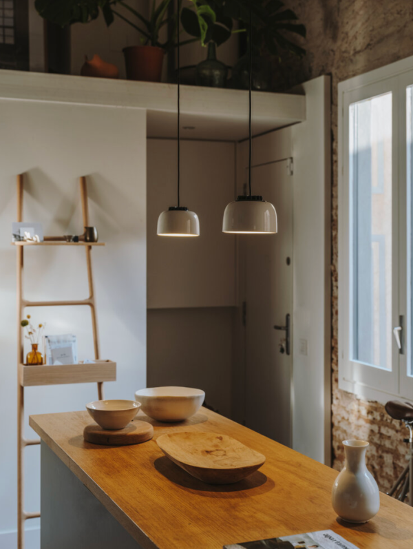 Deux suspensions lumineuses au-dessus d’un plan de travail en bois dans une cuisine au style naturel.