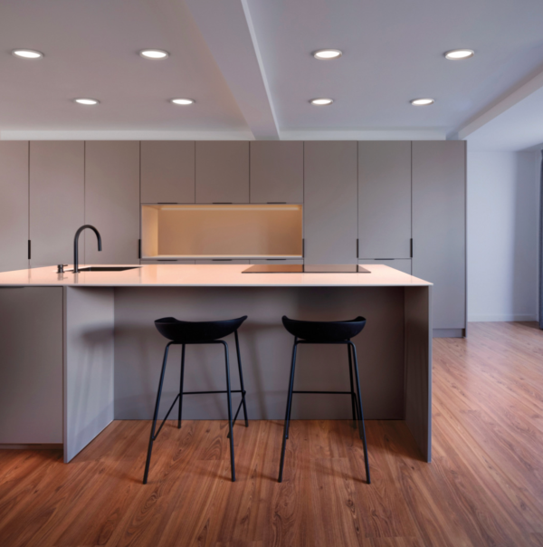 Éclairage encastré au plafond mettant en valeur une cuisine moderne avec îlot central.
