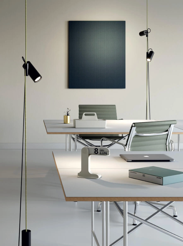 Bright and minimalist workspace with black pendant lights, modern furniture, and a clean atmosphere.
