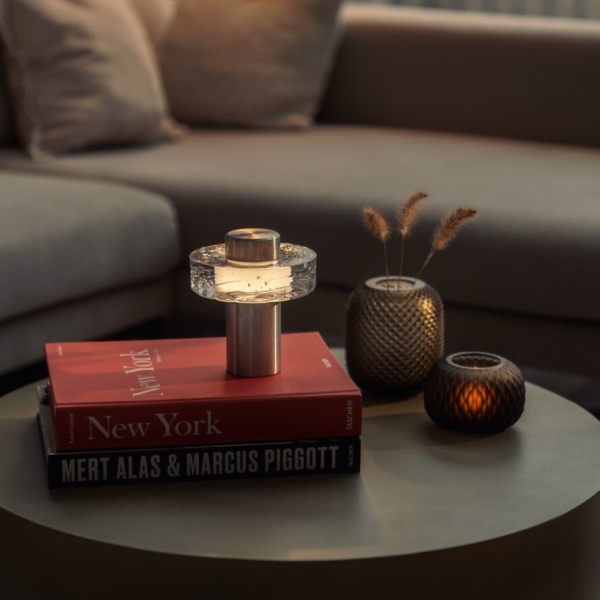 Portable table lamp diffuses indoor light with a glass ring.