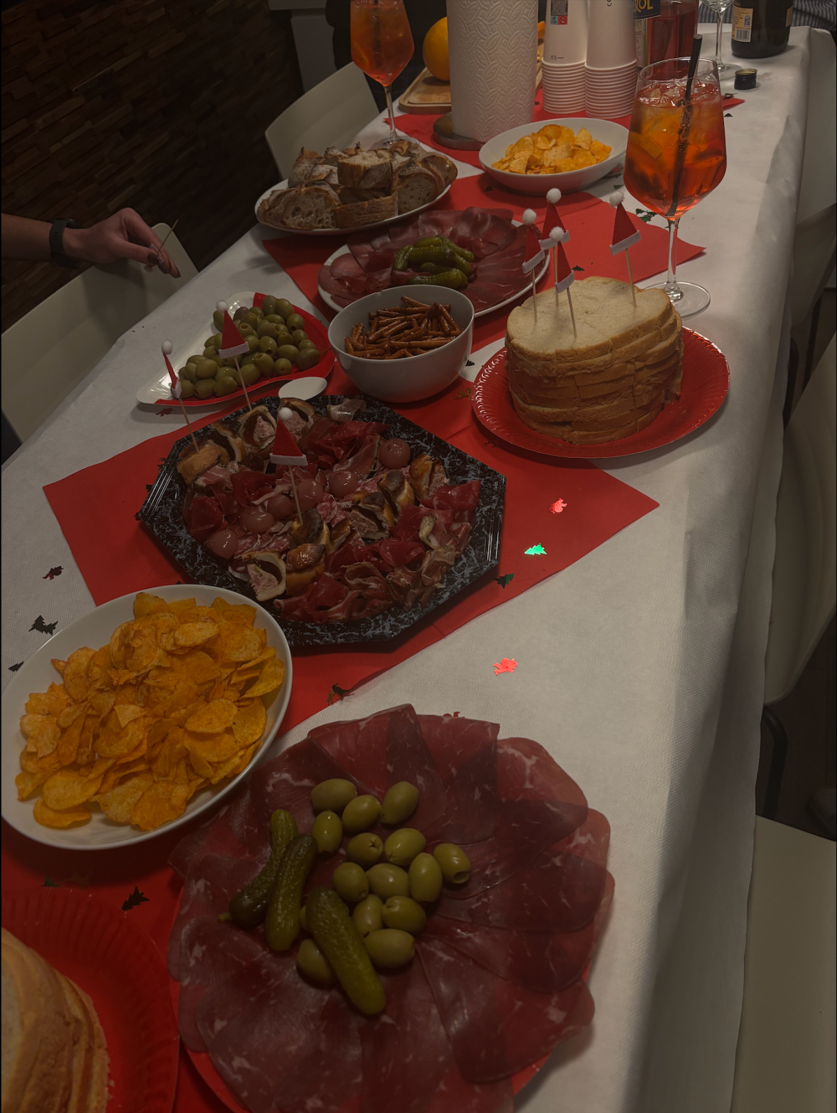 able d’apéritif de Noël avec charcuterie, pain, chips, olives et spritz, dressée pour une soirée conviviale chez Clarma à Lausanne.