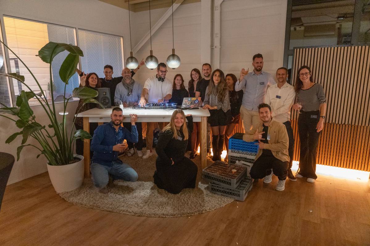 hoto de groupe lors d’un événement interne chez Clarma SA, montrant l’équipe réunie dans un espace convivial autour d’un DJ, souriant et posant devant l’appareil photo.