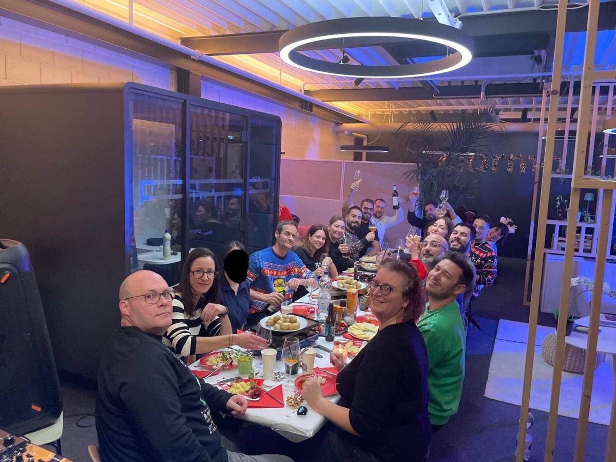 Équipe Clarma réunie autour d’une table lors de la soirée de Noël dans les locaux de Lausanne, partageant un moment convivial autour d’un repas festif.
