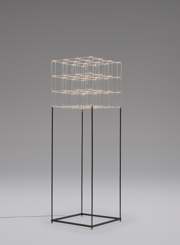 Artistic floor lamp featuring a cubic wireframe structure adorned with multiple light points, mounted on four slender black metal legs forming a square base.