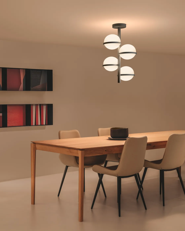 Suspension design composée de sphères lumineuses diffusant une lumière douce au-dessus d’une table de salle à manger.