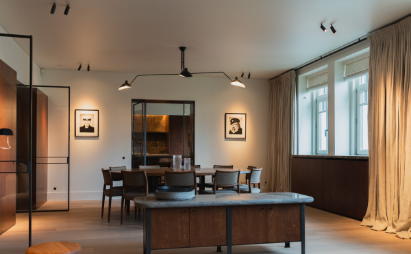 Salle à manger contemporaine éclairée par les projecteurs de plafond Acrojack Mini de Prado, offrant un éclairage directionnel discret et efficace qui met en valeur l’espace et ses œuvres murales.