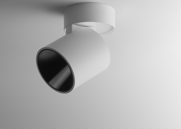 Projecteur blanc orientable en surface au design cylindrique épuré, offrant un éclairage directionnel précis.