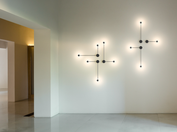 Appliques murales design diffusant une lumière douce et décorative sur un mur blanc.