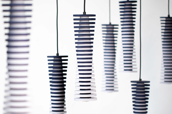 Cylindrical acoustic pendant lights made of stacked rings in blue-to-white gradients, shown in multiple rows against a light background.