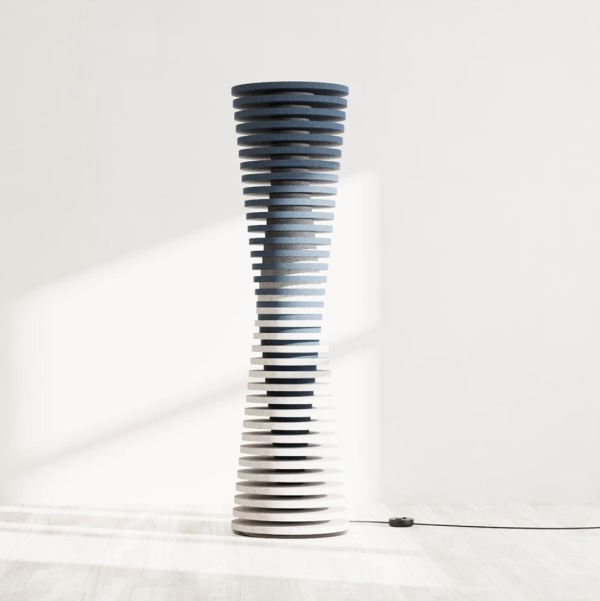 Floor-standing acoustic light made of stacked rings creating a slender silhouette, featuring a gradient from blue to white, placed on a light floor with a visible power cord