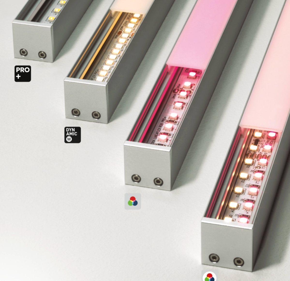 Gros plan sur quatre profilés linéaires LED présentant différentes sources lumineuses : Pro+, Dynamic White, RGB et RGBW, illustrant la variété d’options d’éclairage offertes par la gamme.