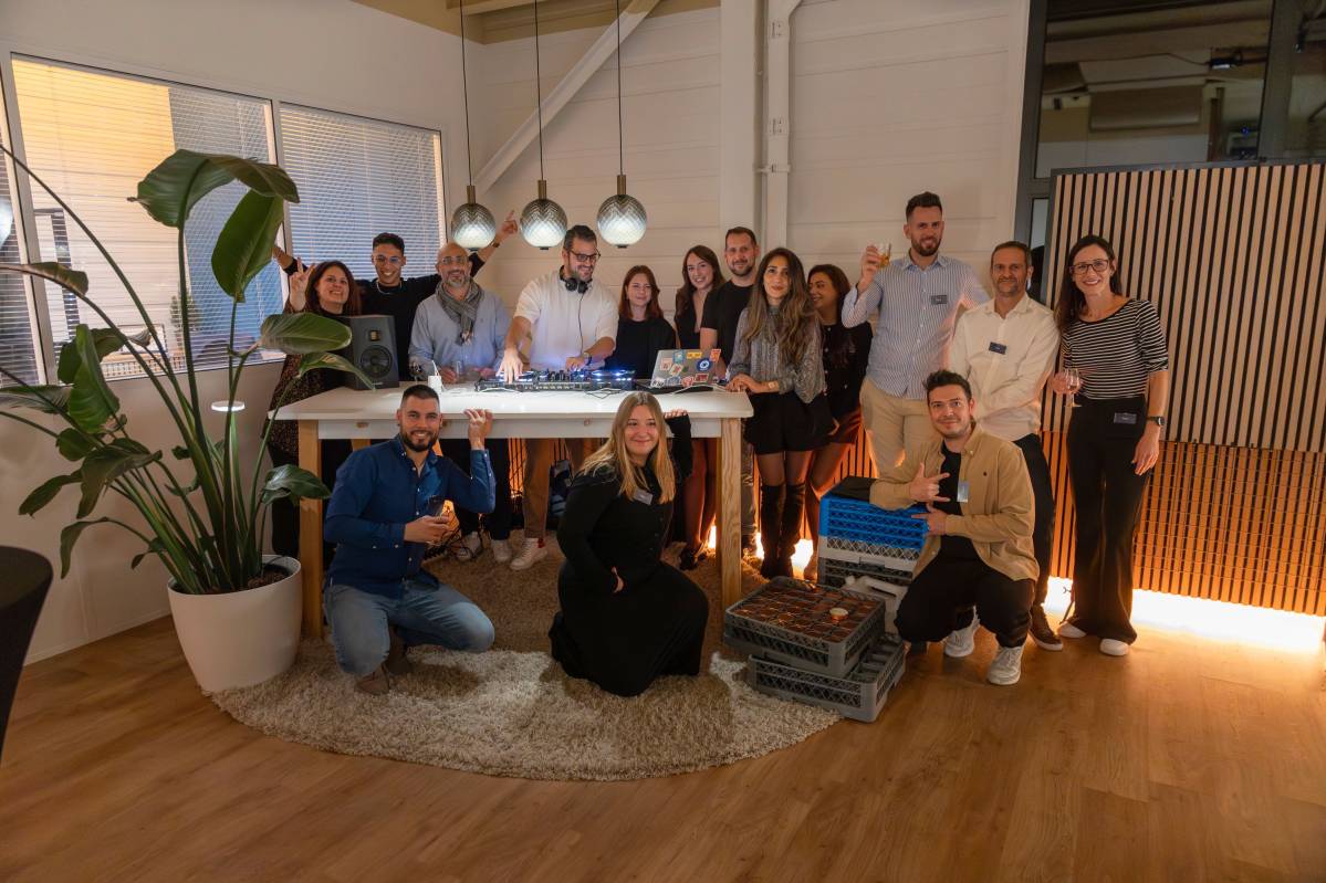 Photo de groupe lors d’un événement interne chez Clarma SA, montrant l’équipe réunie dans un espace convivial autour d’un DJ, souriant et posant devant l’appareil photo