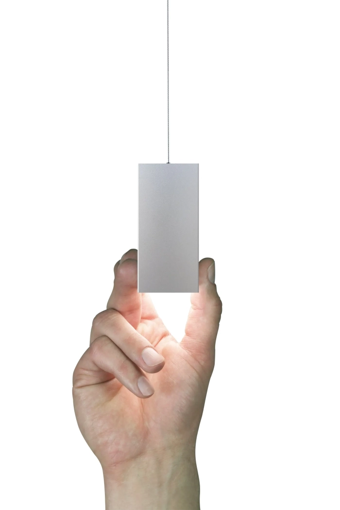 Luminaires linéaires Kalis de Intra Lighting suspendus au plafond noir d’un espace collaboratif moderne, avec gradins en bois, poufs design et tapis bleu, décoré d’un mur graphique en noir et blanc.